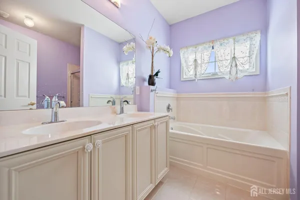 a bathroom with a sink a vanity a mirror and a bathtub