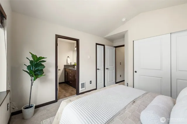 a bedroom with a bed and a potted plant