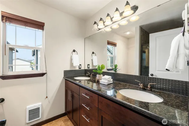 a bathroom with a granite countertop sink and a mirror