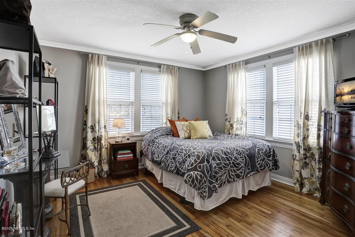 3940 Gadsden Road Jacksonville, FL 32207 - Photo 11 of 17 a bedroom with a bed a flat screen tv and a large window with the outer view