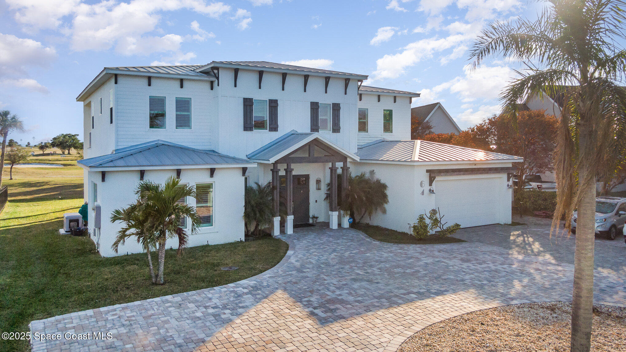64 Country Club Road Cocoa Beach, FL 32931 - Photo 1 of 1 a front view of a house with a yard and trees
