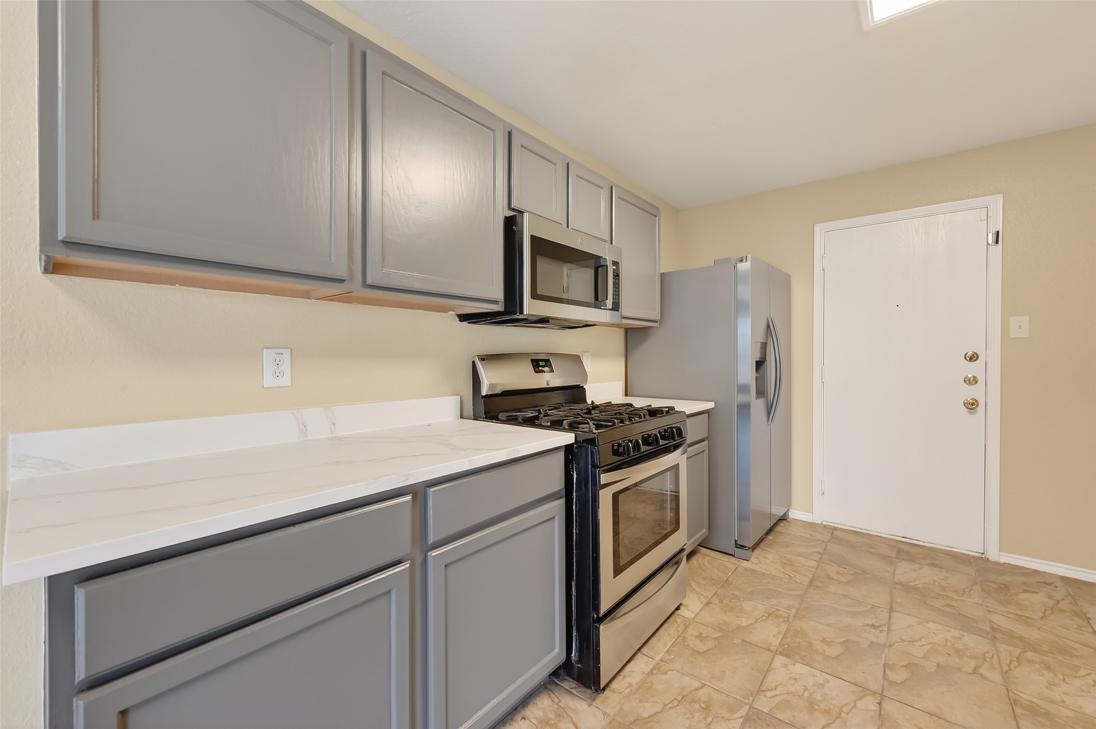 22802 Sherioaks Lane Spring, TX 77389 - Photo 5 of 37 Stylish gray cabinetry paired crisp white countertops, creating a clean and modern look. Designed for plenty of space to move around, this open layout offer both functionality and comfort.