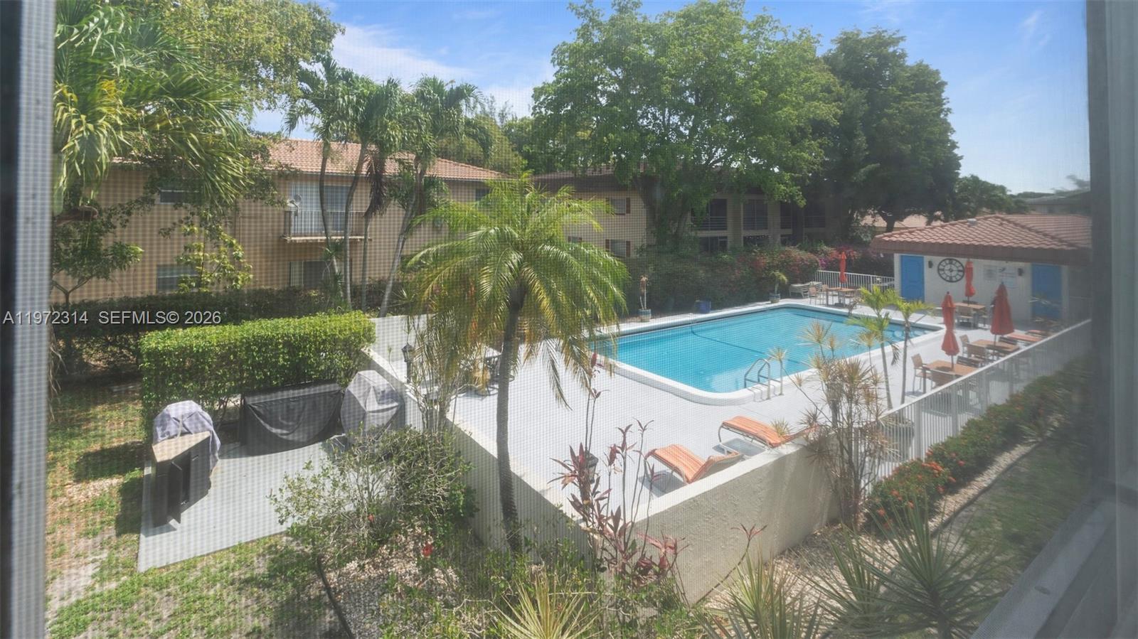 8605 West Sample Road, Unit 202 Coral Springs, FL 33065 - Photo 19 of 26 a view of a swimming pool with a patio