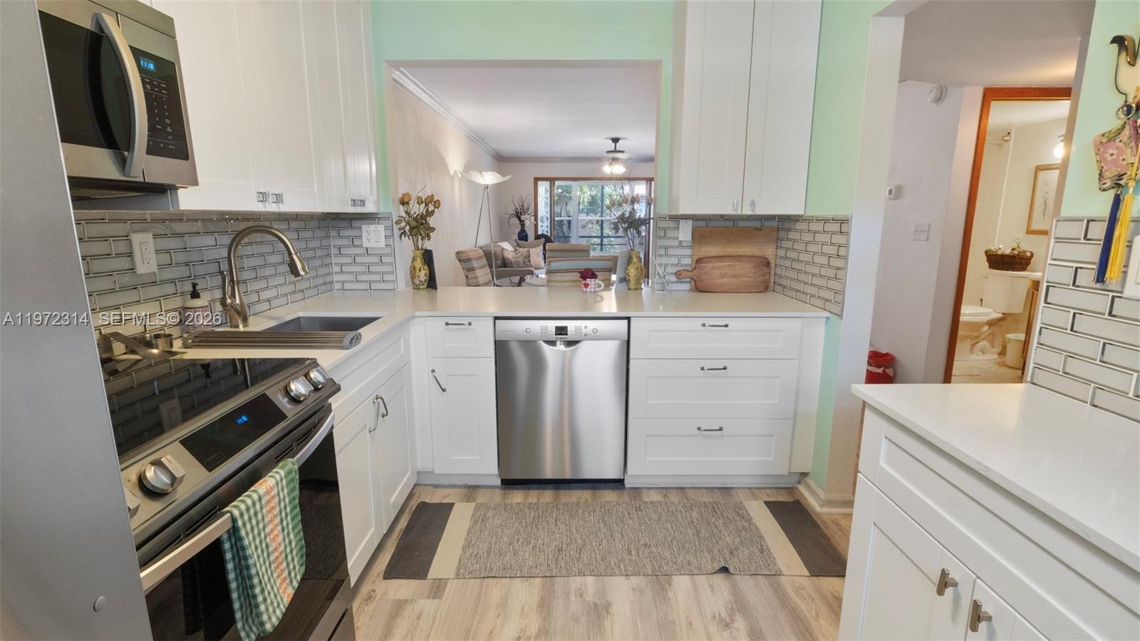 8605 West Sample Road, Unit 202 Coral Springs, FL 33065 - Photo 2 of 26 a kitchen with a sink stove and cabinets