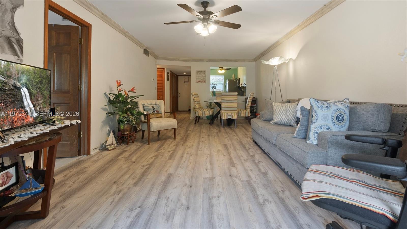 8605 West Sample Road, Unit 202 Coral Springs, FL 33065 - Photo 3 of 26 a living room with furniture and a flat screen tv