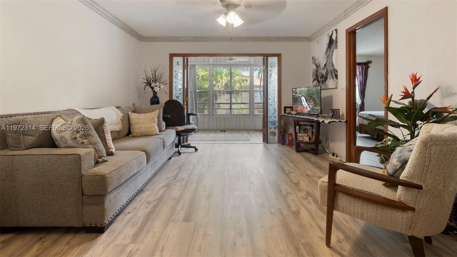 8605 West Sample Road, Unit 202 Coral Springs, FL 33065 - Photo 4 of 26 a living room with furniture and a large window