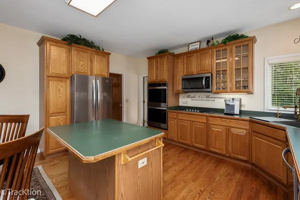 a kitchen with stainless steel appliances granite countertop a refrigerator a stove top oven a sink and dishwasher