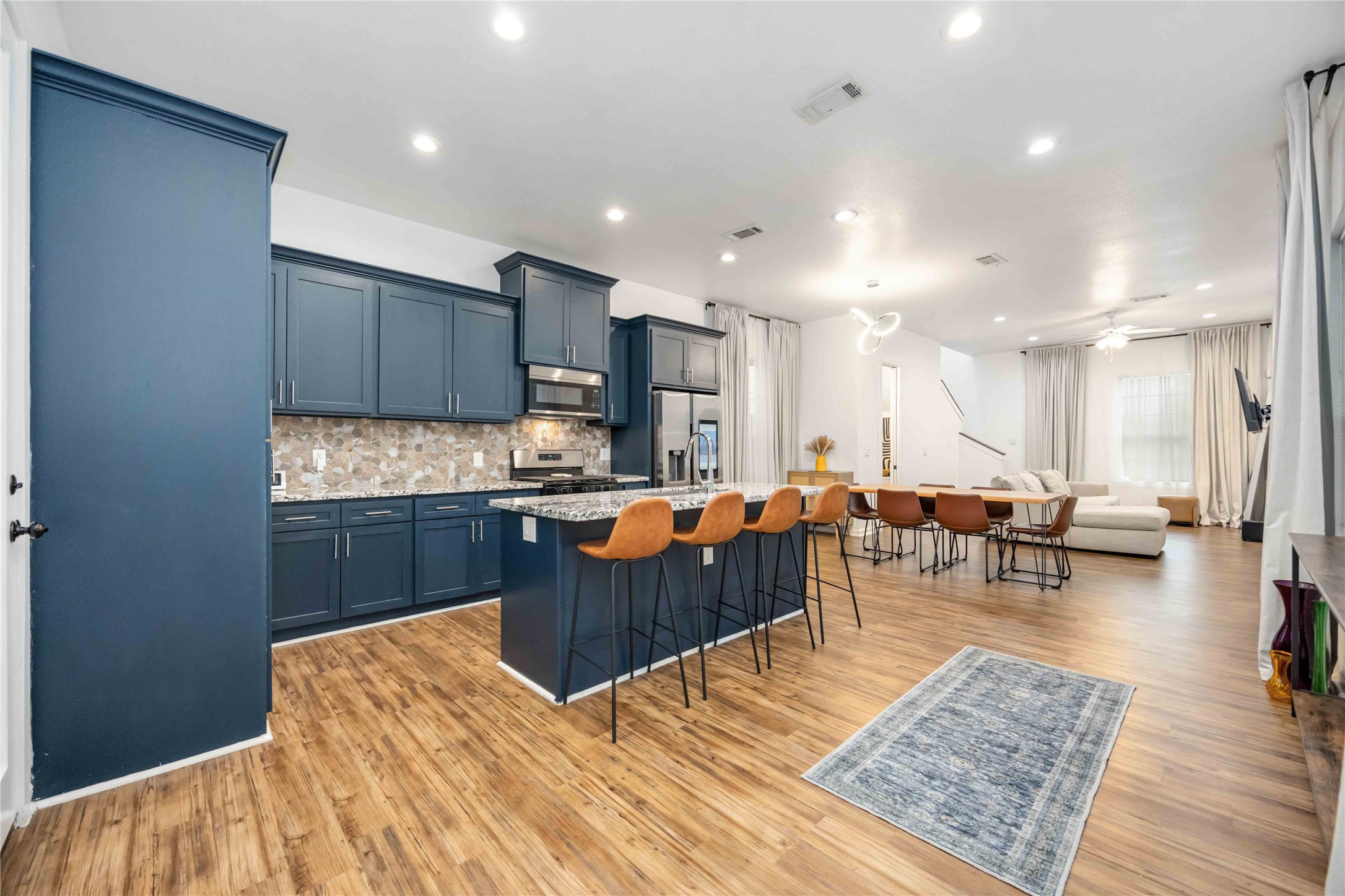 a living room with lots of furniture and kitchen view