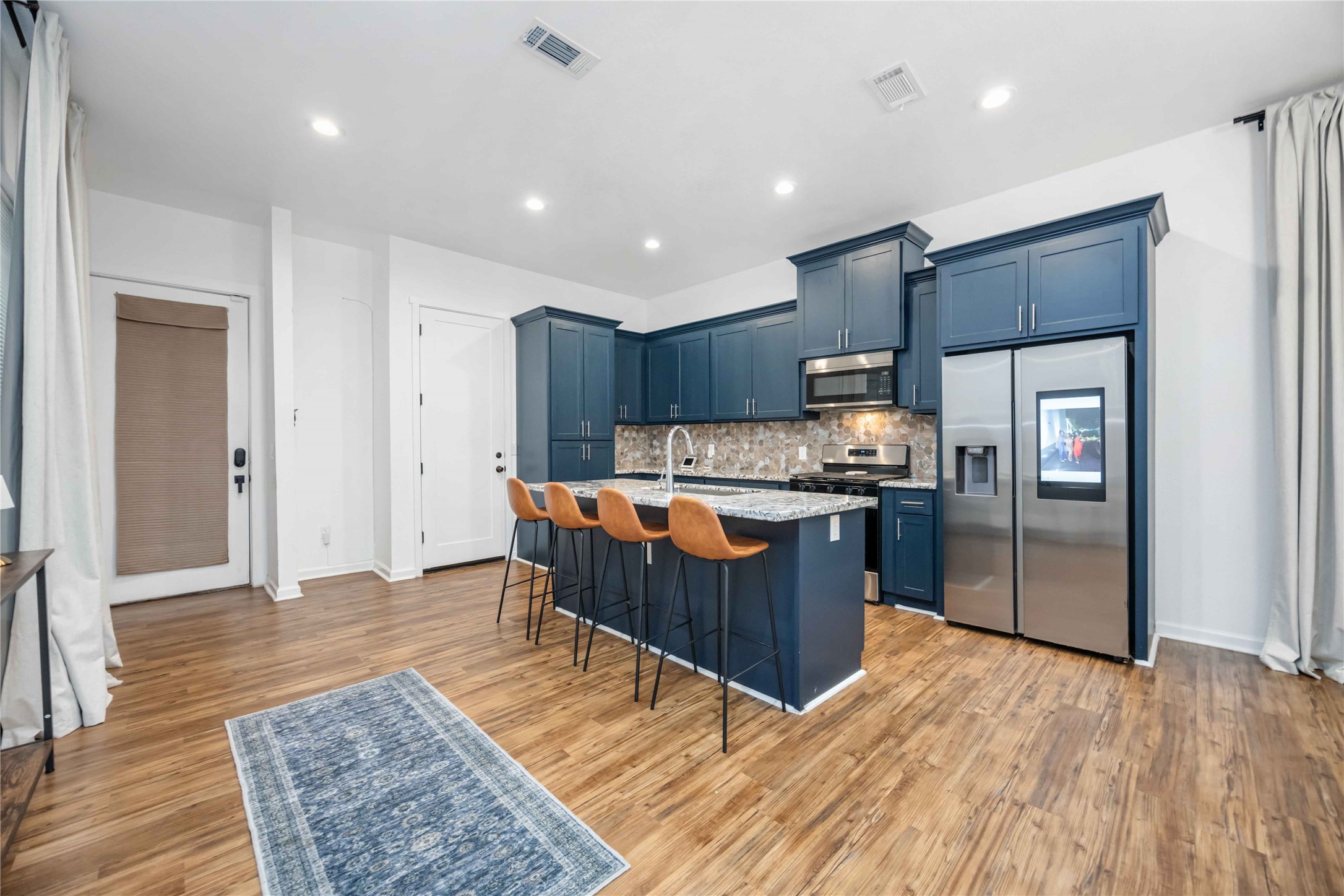 14108 Bridgeport Road, Unit B Houston, TX 77047 - Photo 5 of 24 a kitchen with stainless steel appliances granite countertop a refrigerator a sink a stove a microwave and island