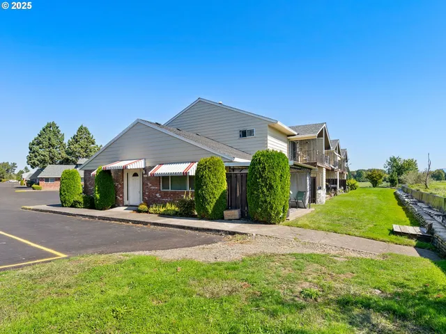 a front view of a house with a yard and potted plants