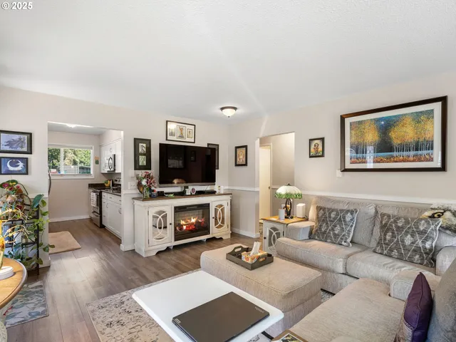 a living room with furniture kitchen view and a flat screen tv