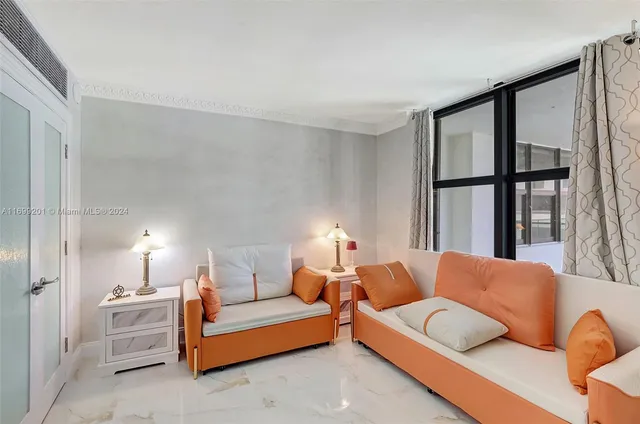 a bedroom with furniture and a large window