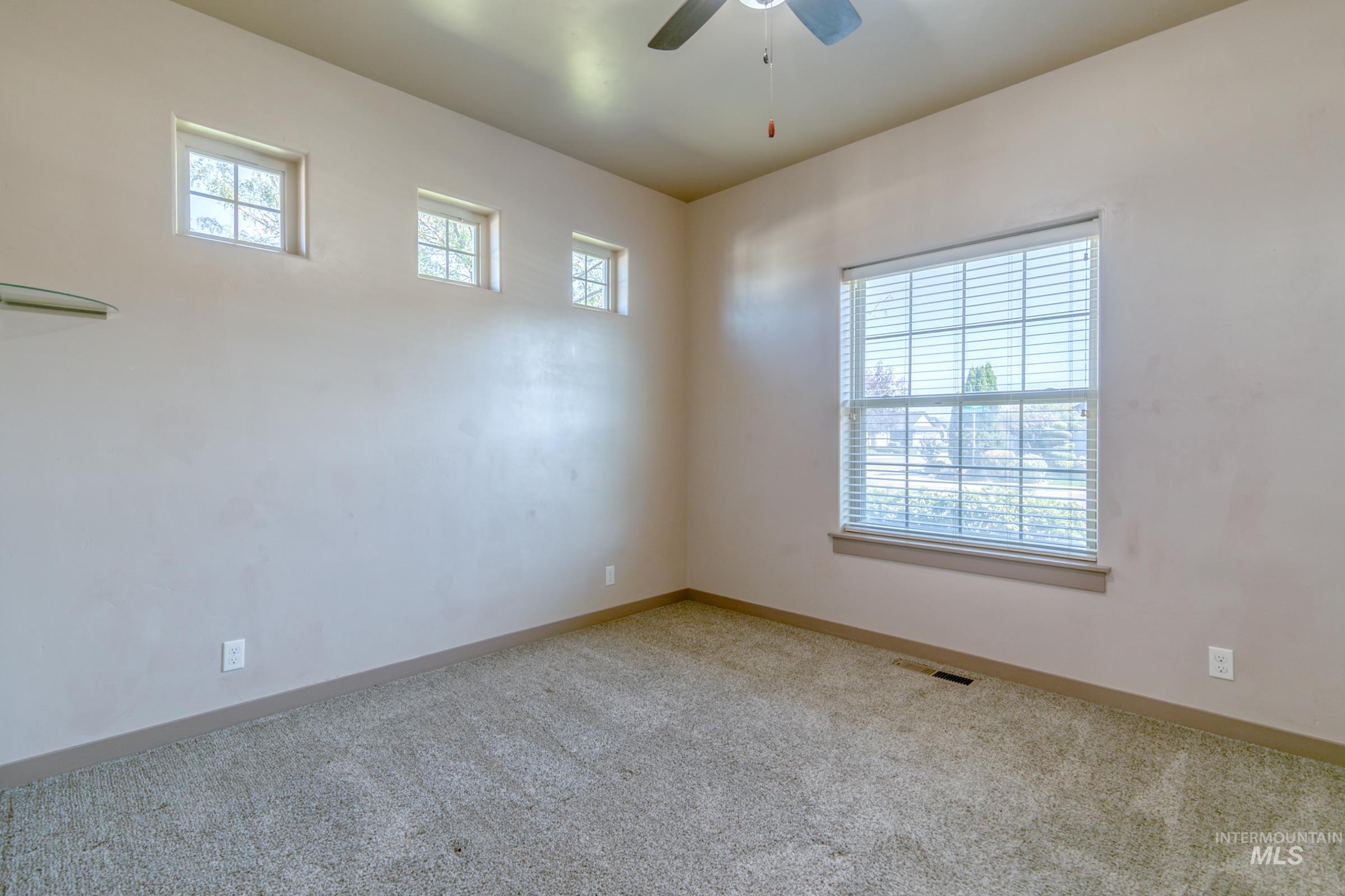 4316 Middlesboro Way Caldwell, ID 83607 - Photo 16 of 33 Expansive room featuring wood-finish flooring, a multi-light chandelier, and multiple windows with blinds