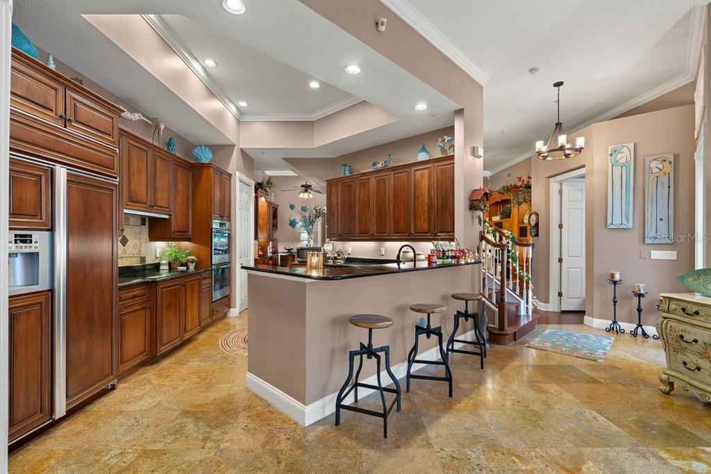 4606 Oak Hammock Court, Unit 4606 Ponce Inlet, FL 32127 - Photo 26 of 92 a kitchen with refrigerator and chairs