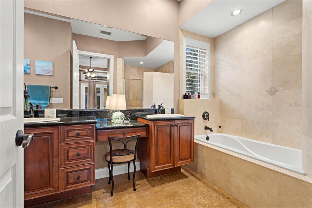 4606 Oak Hammock Court, Unit 4606 Ponce Inlet, FL 32127 - Photo 35 of 92 a bathroom with a granite countertop sink mirror and a bathtub
