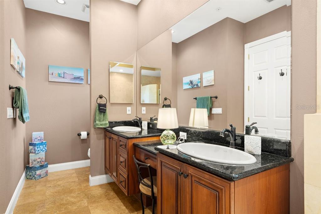4606 Oak Hammock Court, Unit 4606 Ponce Inlet, FL 32127 - Photo 36 of 92 a bathroom with a granite countertop sink a toilet and a mirror