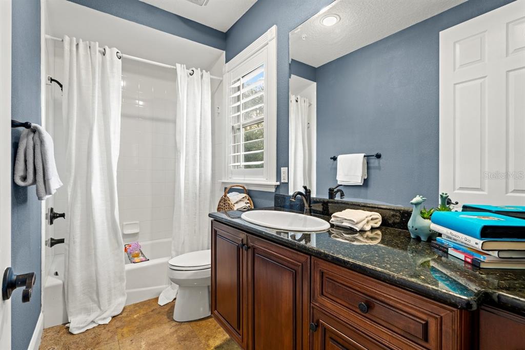4606 Oak Hammock Court, Unit 4606 Ponce Inlet, FL 32127 - Photo 46 of 92 a spacious bathroom with a granite countertop sink a toilet a large mirror and shower curtain