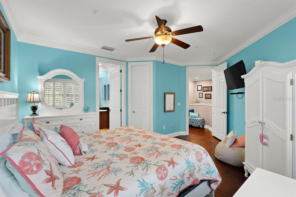 4606 Oak Hammock Court, Unit 4606 Ponce Inlet, FL 32127 - Photo 49 of 92 a bedroom with a bed and a chandelier