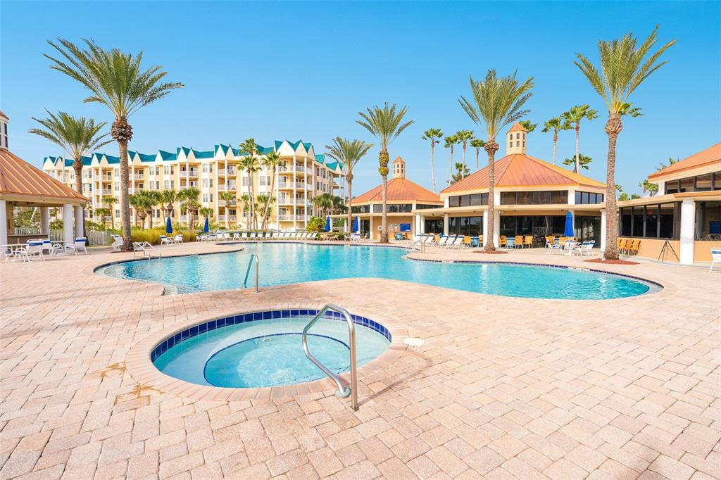 4606 Oak Hammock Court, Unit 4606 Ponce Inlet, FL 32127 - Photo 75 of 92 a view of a swimming pool with a lawn chairs under an umbrella