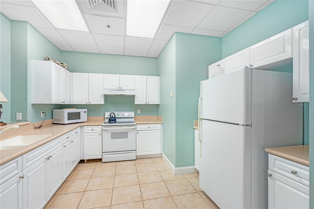 4606 Oak Hammock Court, Unit 4606 Ponce Inlet, FL 32127 - Photo 84 of 92 a kitchen with a white refrigerator and a sink