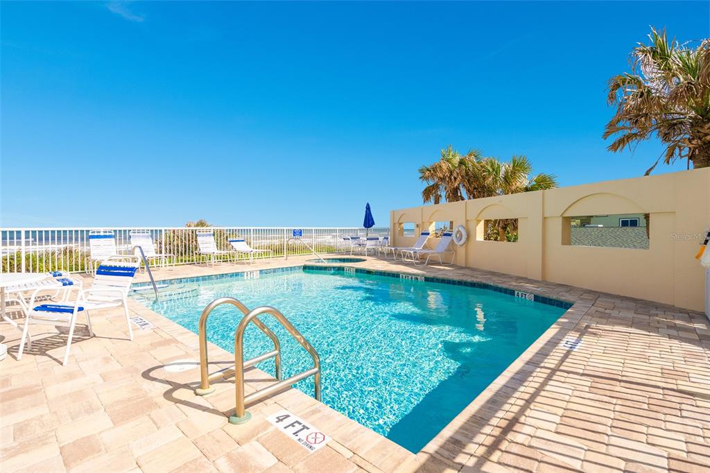 4606 Oak Hammock Court, Unit 4606 Ponce Inlet, FL 32127 - Photo 89 of 92 a view of a swimming pool with a lounge chairs