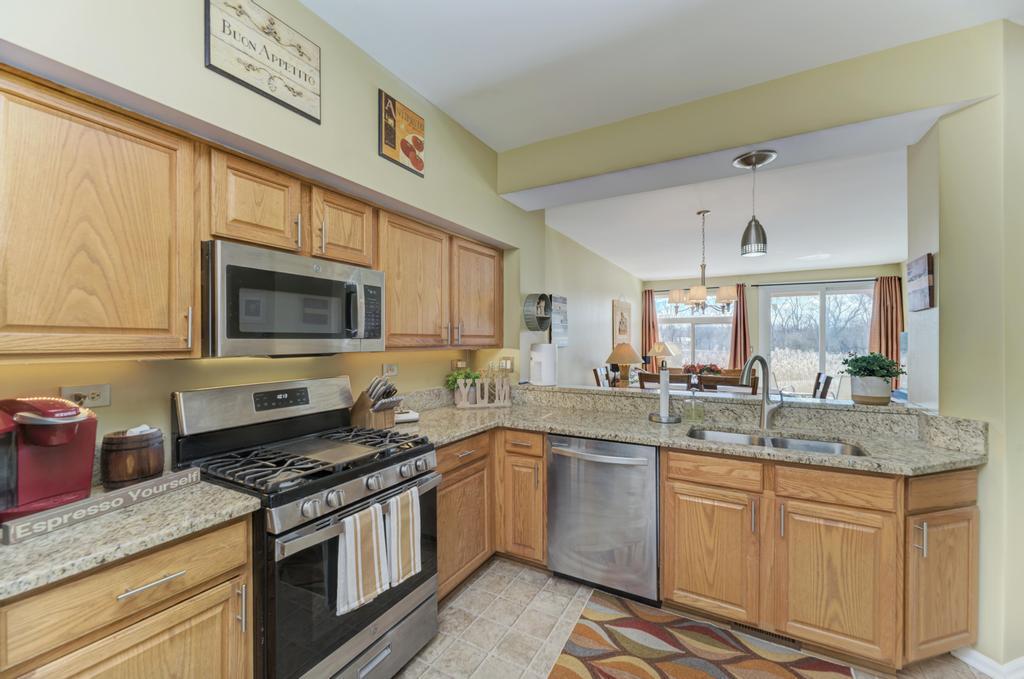 8321 Ripple Ridge Darien, IL 60561 - Photo 15 of 27 a kitchen with stainless steel appliances granite countertop a sink stove and microwave
