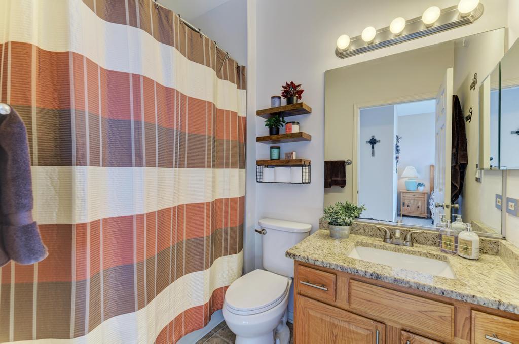 8321 Ripple Ridge Darien, IL 60561 - Photo 19 of 27 a bathroom with a granite countertop toilet sink and mirror