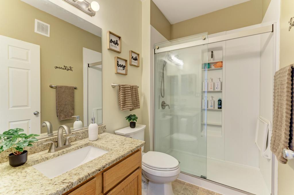 8321 Ripple Ridge Darien, IL 60561 - Photo 23 of 27 a bathroom with a granite countertop sink toilet mirror and shower