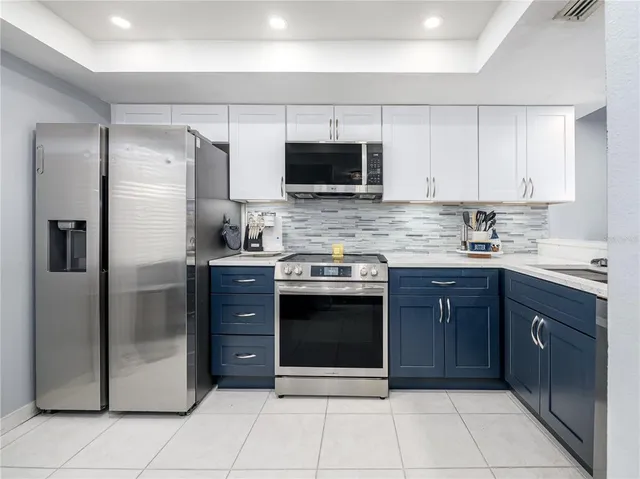 a kitchen with stainless steel appliances granite countertop a refrigerator and a sink