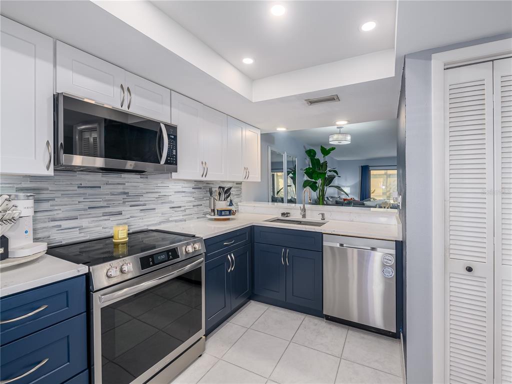 120 Caryl Way Oldsmar, FL 34677 - Photo 4 of 25 a kitchen with stainless steel appliances granite countertop a sink and stove top oven