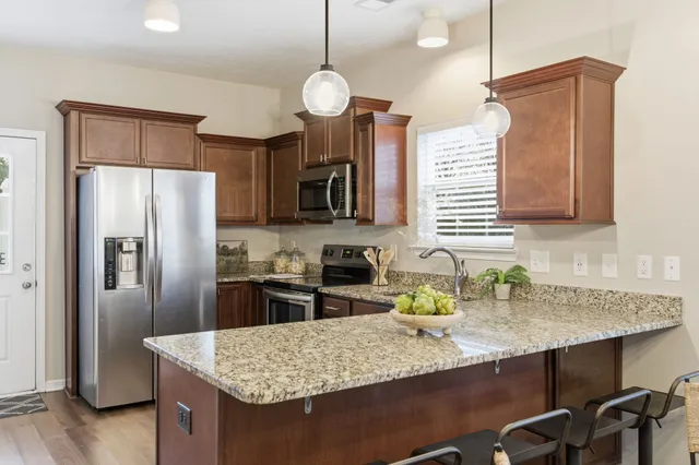 a kitchen with stainless steel appliances granite countertop a sink refrigerator and microwave
