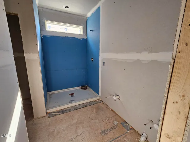 a bathroom with a tub a mirror and a shower