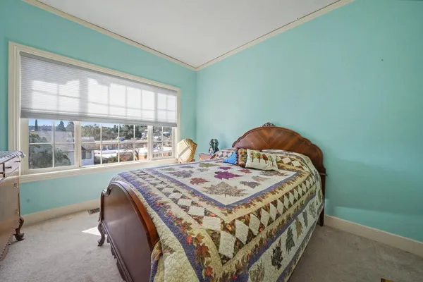 a bed sitting in a bedroom next to a window