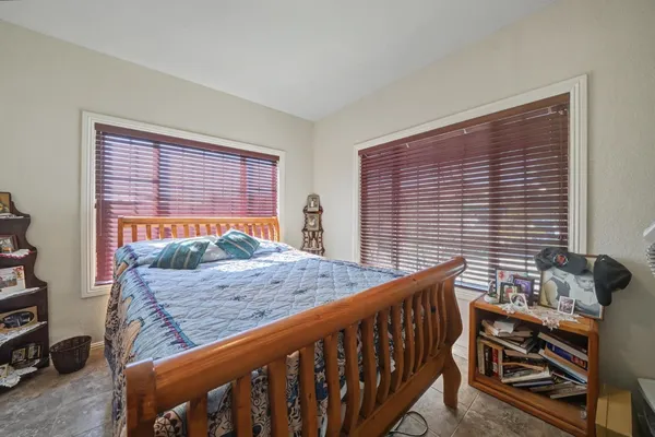 a bedroom with a bed next to a window
