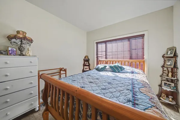 a bed sitting in a bedroom next to a window with dresser