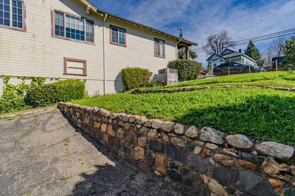 a view of a house with a yard and flower plants