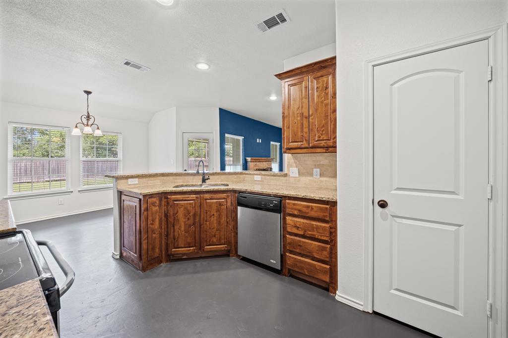 229 Firefly Drive Springtown, TX 76082 - Photo 6 of 33 Kitchen featuring wood cabinetry, light stone countertops, integrated stainless steel dishwasher, and a sink with a gooseneck faucet