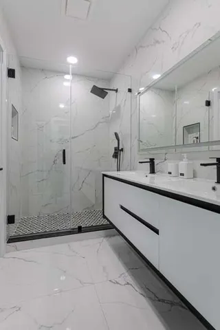 a bathroom with a sink a mirror and shower