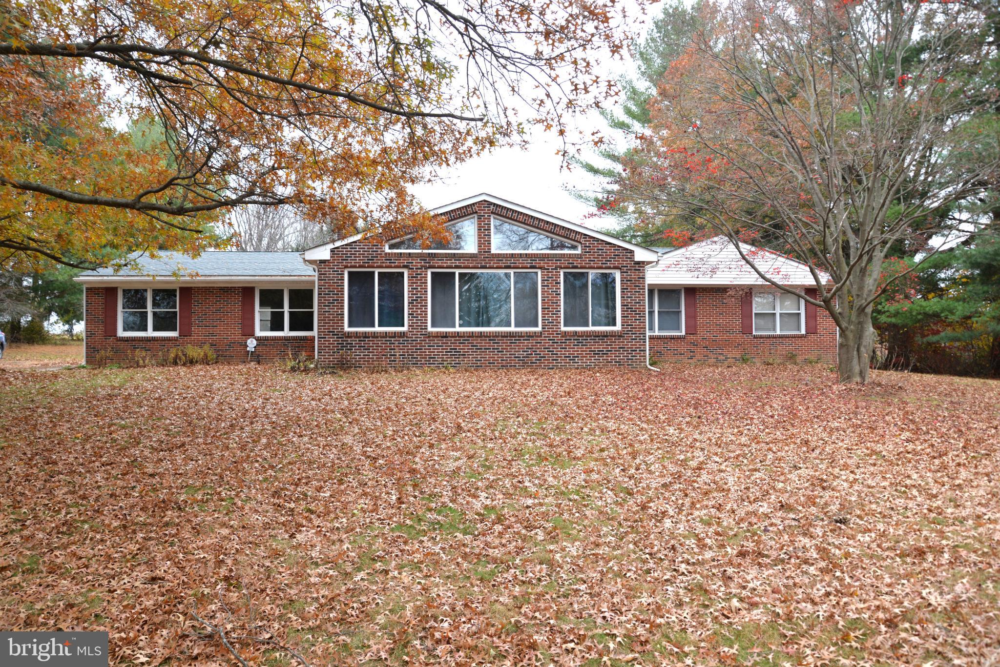 Charming brick home amidst autumn leaves.