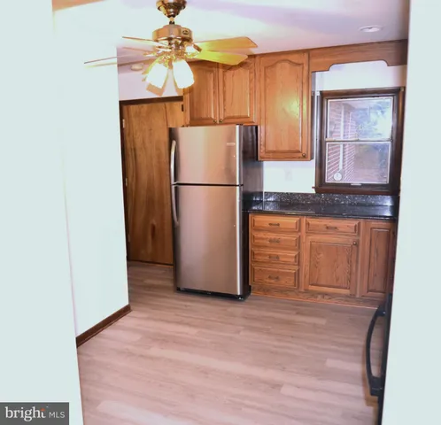 a kitchen with granite countertop a refrigerator and a sink