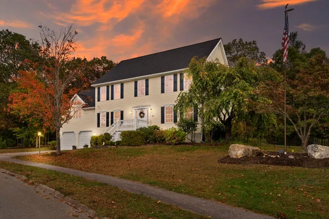 a view of a white house next to a road and yard
