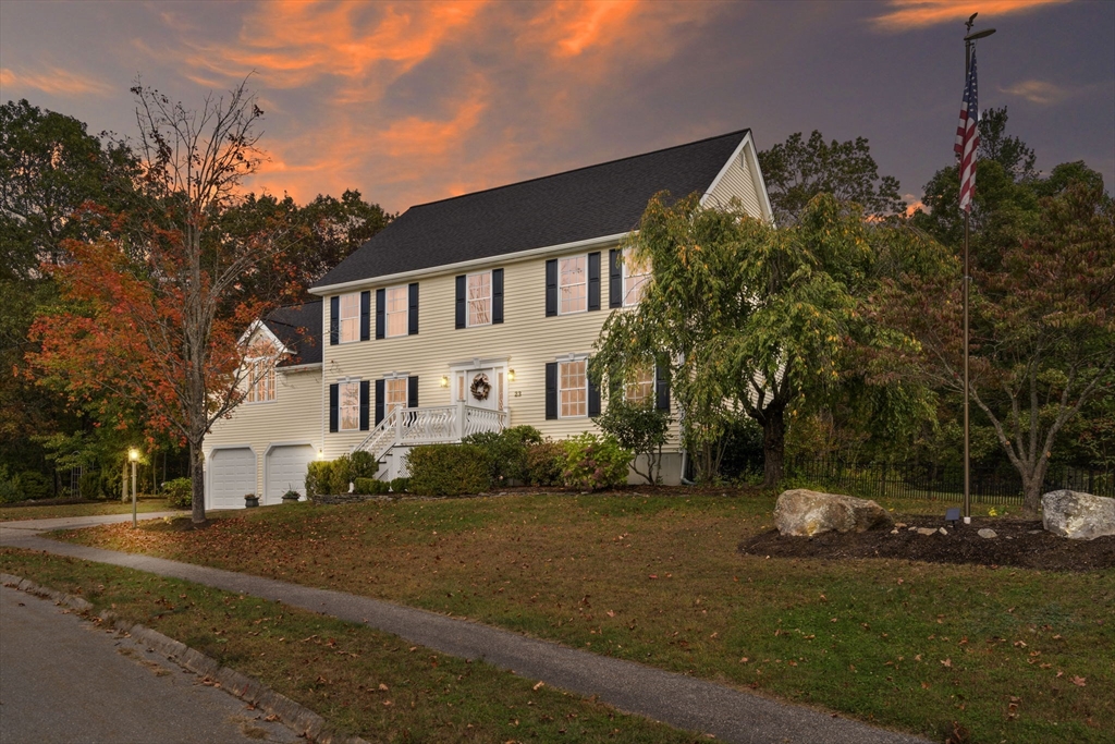 a view of a white house next to a road and yard