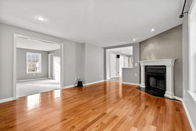 an empty room with windows and fireplace