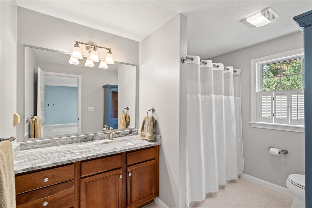 23 Morrison Lane Westford, MA 01886 - Photo 29 of 37 a bathroom with a granite countertop sink a toilet and a mirror