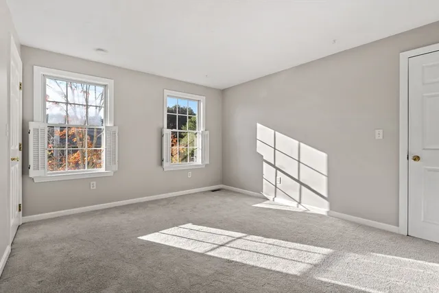 an empty room with windows and closet