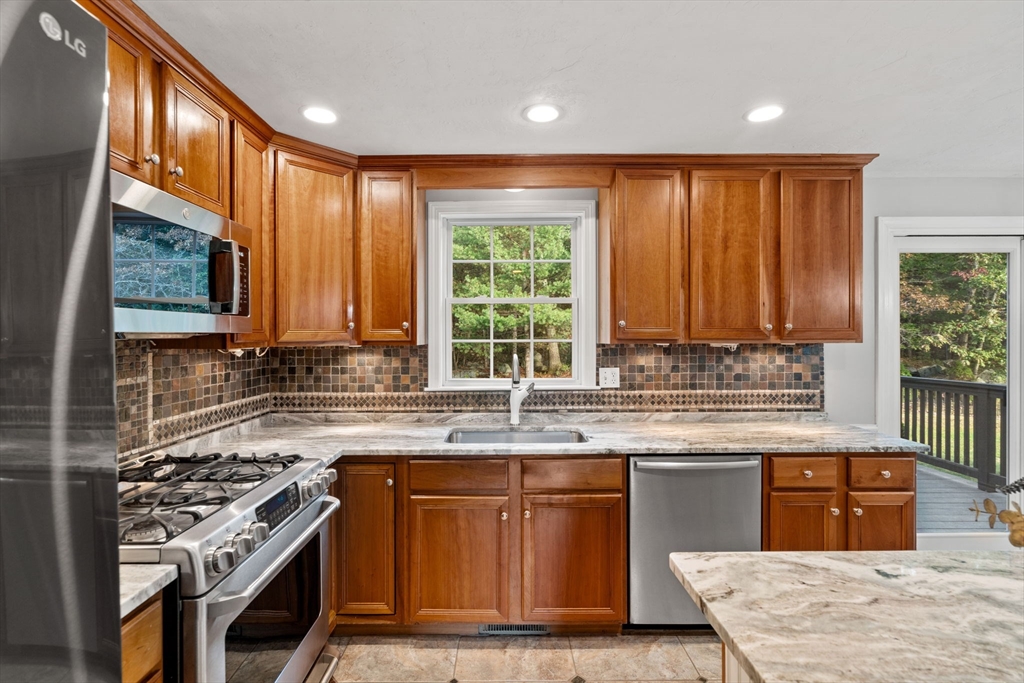 23 Morrison Lane Westford, MA 01886 - Photo 7 of 37 a kitchen with stainless steel appliances granite countertop a stove a sink and a microwave