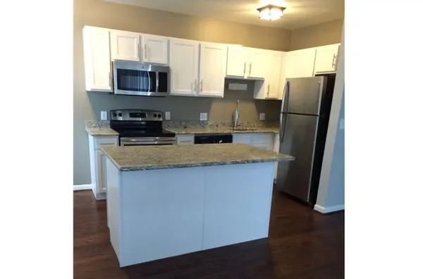 a kitchen with stainless steel appliances granite countertop a refrigerator a stove a sink and a microwave