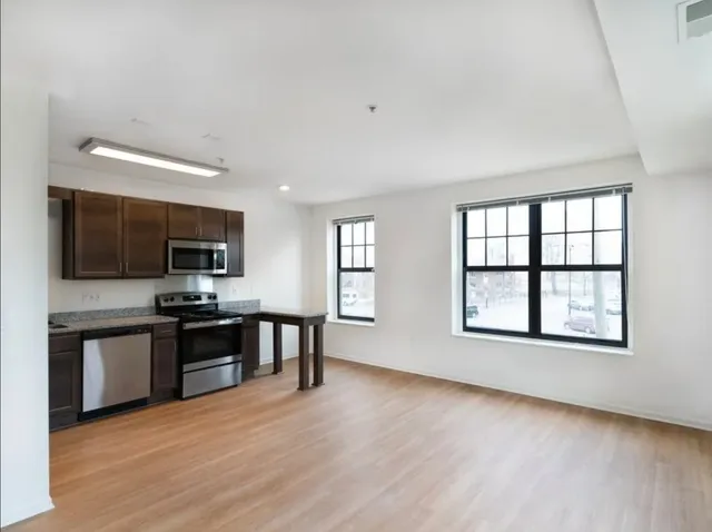 a view of a kitchen with a sink microwave and cabinets