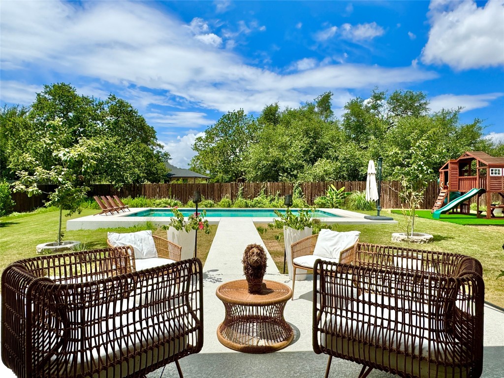 a view of a swimming pool and deck with a yard