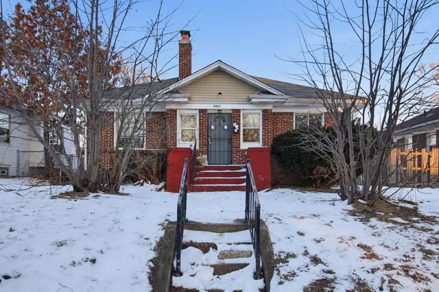 a front view of a house with a yard covered in snow